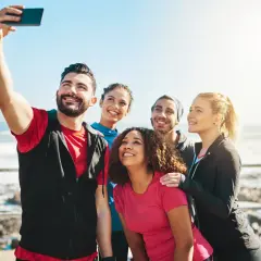 Grupa przyjaciół robi sobie selfie nad morzem. Ich uśmiechy to najlepsze cytaty o sobie, pełne radości i wspólnych chwil.