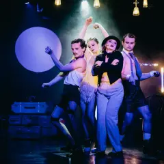 Czterech artystów na scenie, w teatralnych strojach, tworzy atmosferę o nierządne królestwo i zginienia bliskie.