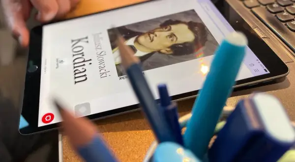 Tablet z portretem Juliusza Słowackiego i napisem "Kordian", obok piórnik z pisakami.