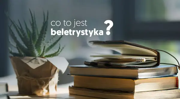 Co to jest beletrystyka? Stos książek i notes z ołówkiem na biurku, obok rośliny.